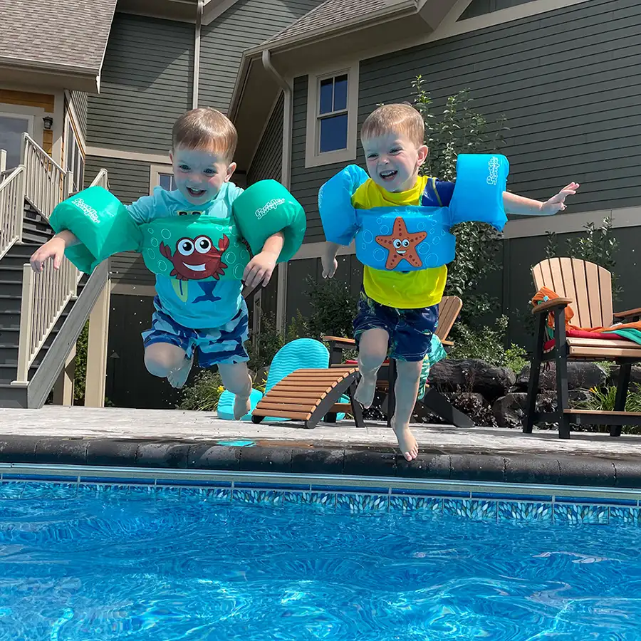 two little boys jump into swimming pool, both are wearing protective floaties, water wings to aid their swimming - pool accessories - Decatur, IL