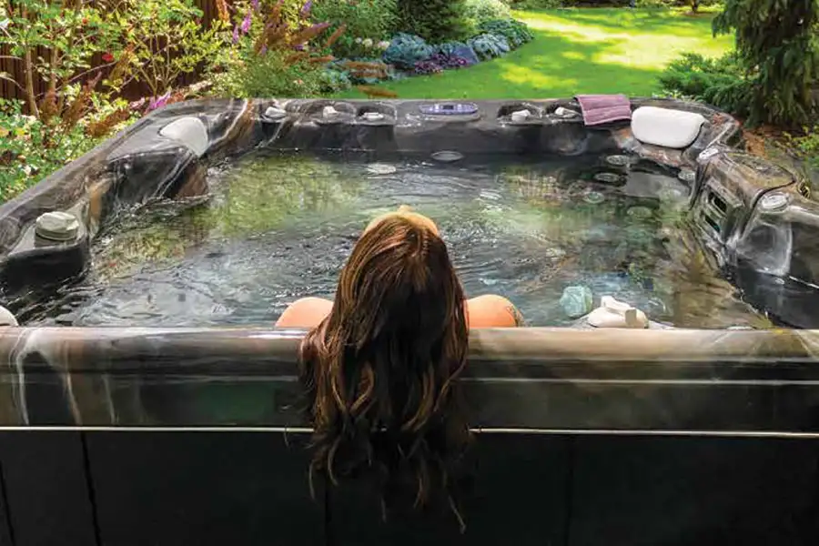 young woman is relaxing in a Northern Bay hot tub in her back garden - Decatur, IL